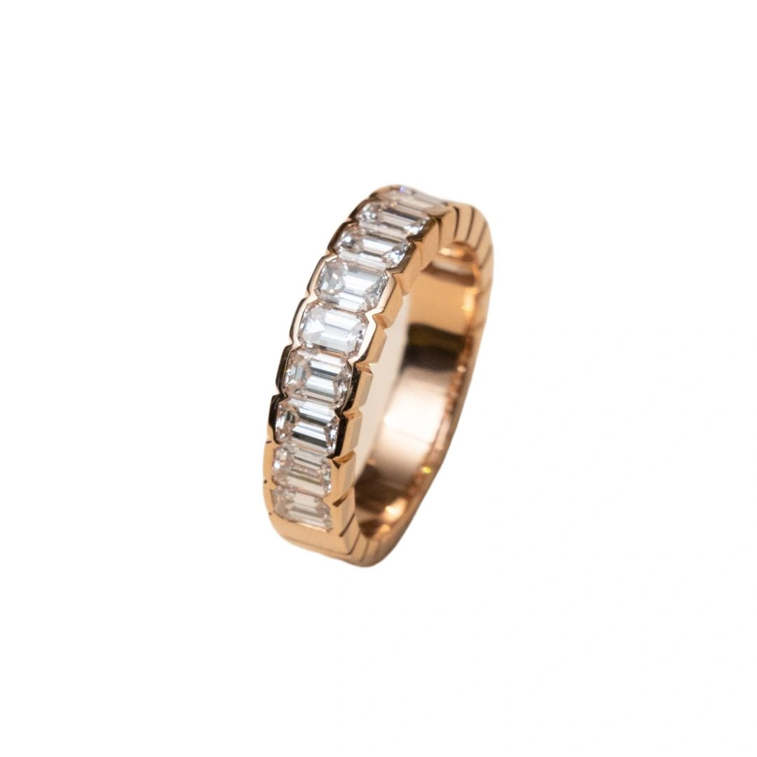 Rose Gold Emerald Cut Bezel Eternity Ring on background
