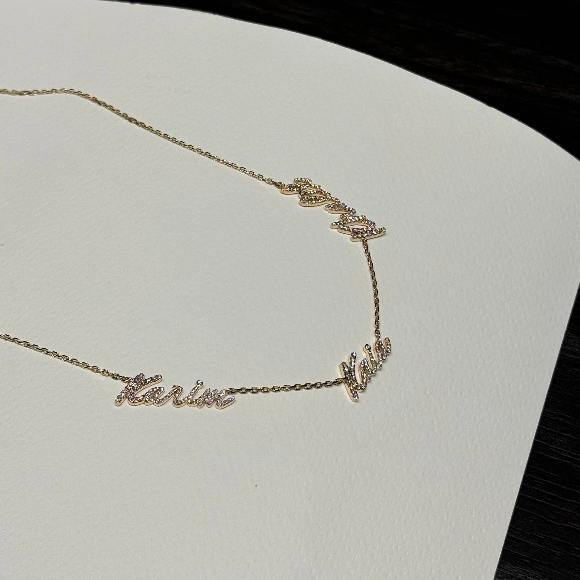 Yellow gold three name necklace on white background