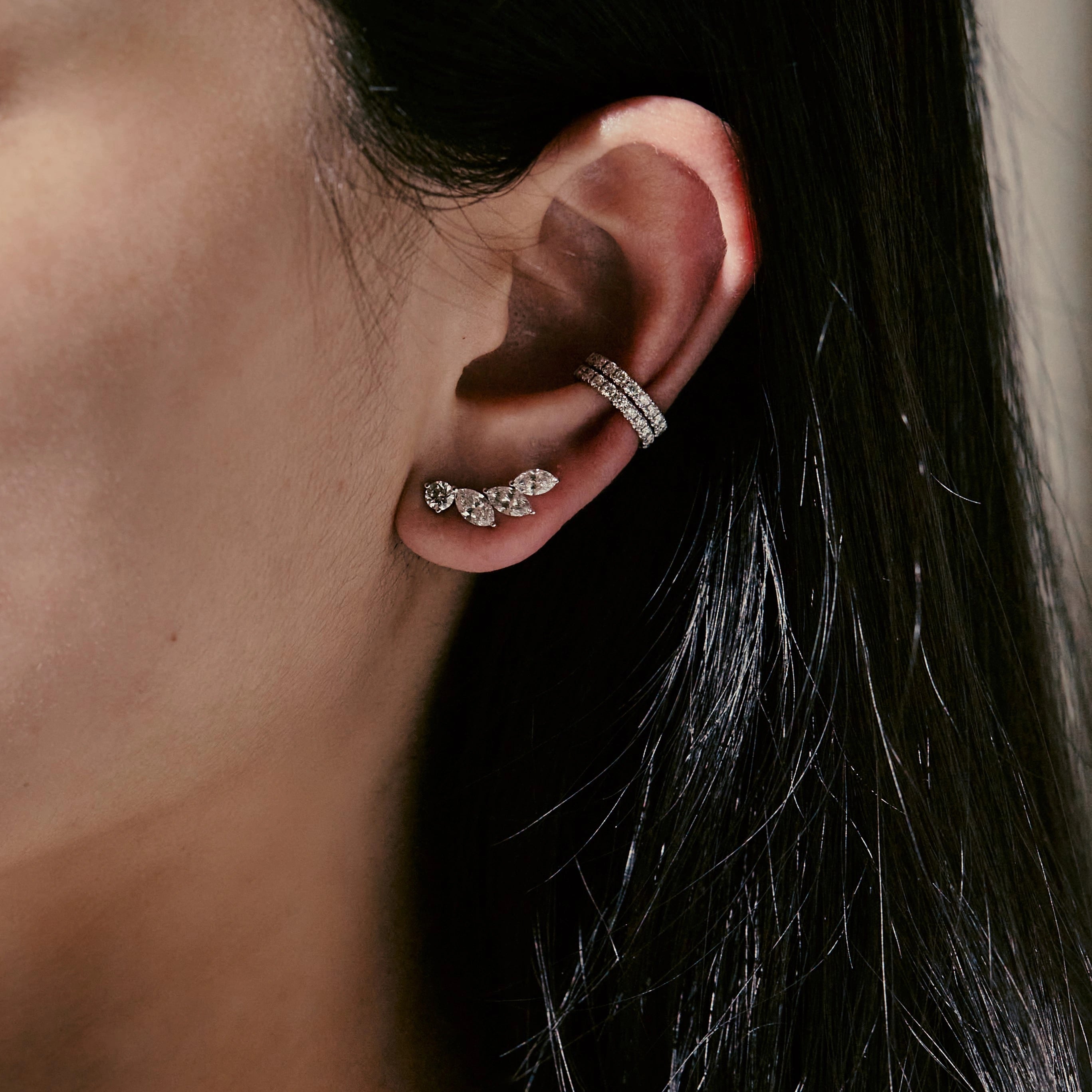 Close-up of an ear wearing two diamond earrings