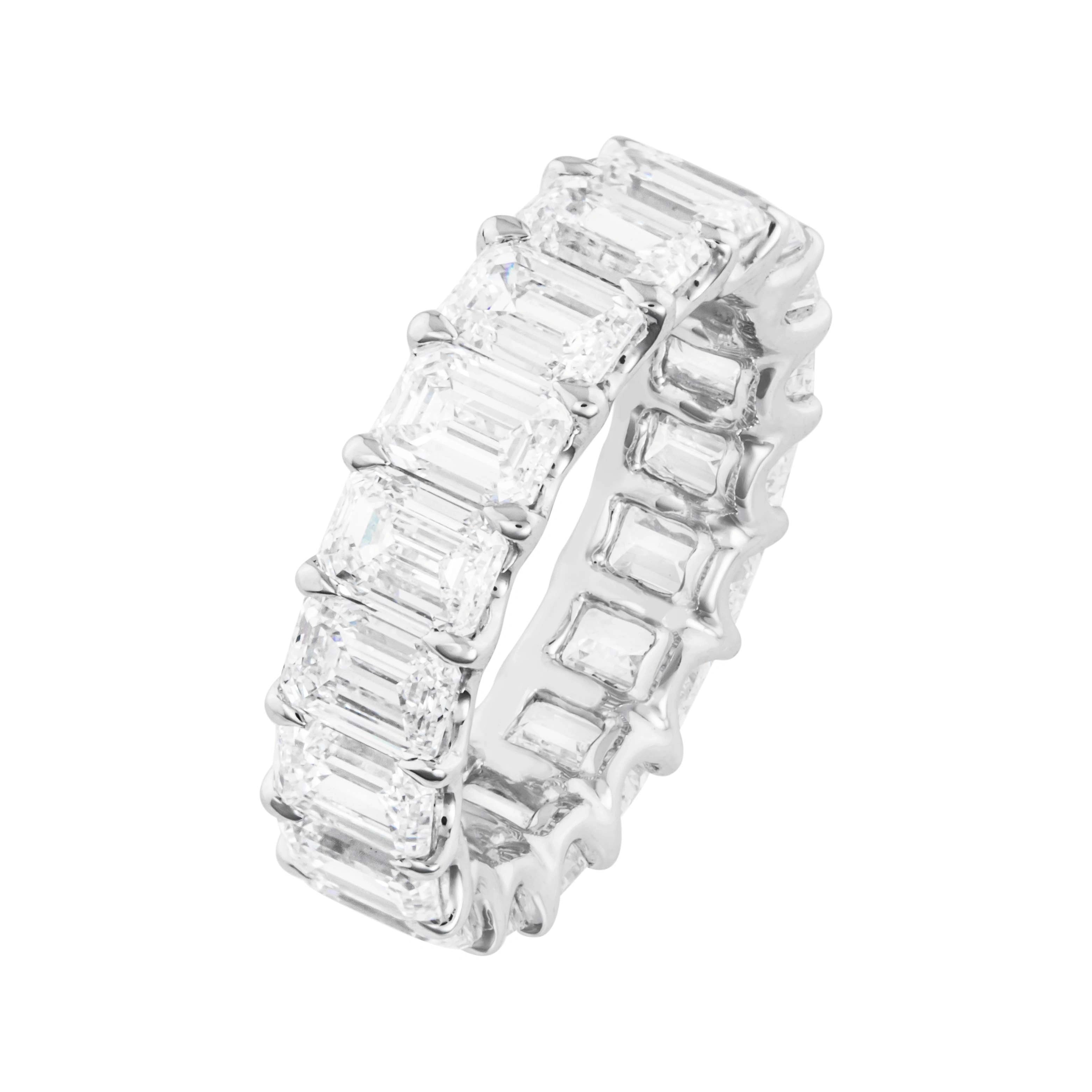 Diamond ring with emerald-cut stones on white background