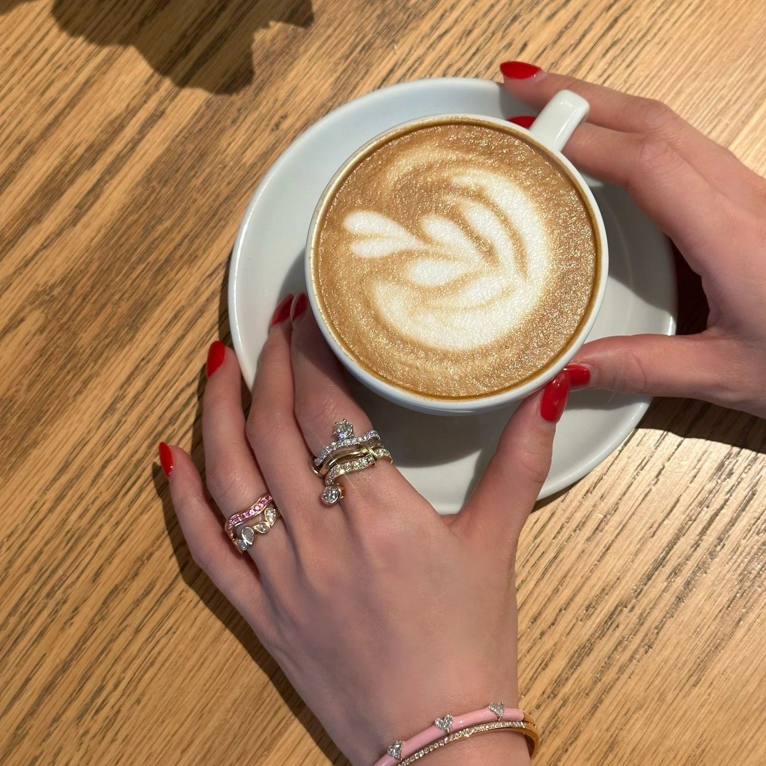 Wearing Trio Diamond Ring with holding a cup of cappuccino