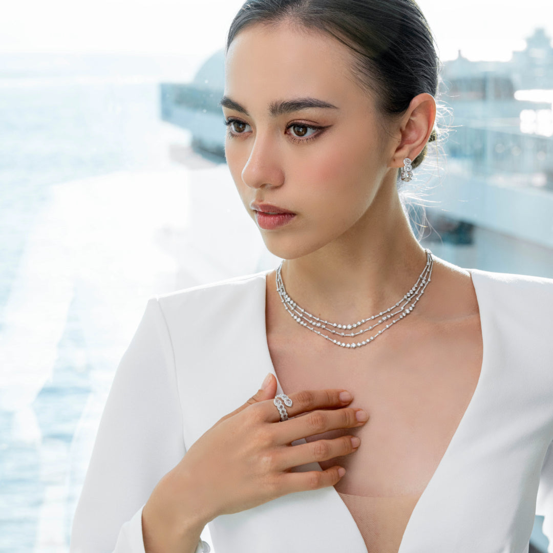Woman wearing a necklace and ring with a blurred background